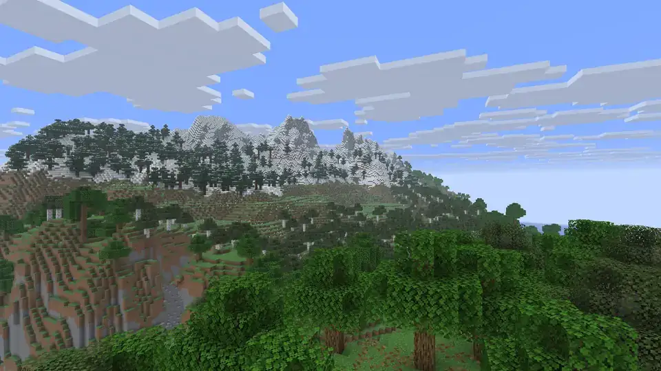 A Minecraft Java Edition Overworld landscape: snow-capped mountain peaks above a spruce forest, with leafy trees in the foreground under a blue sky